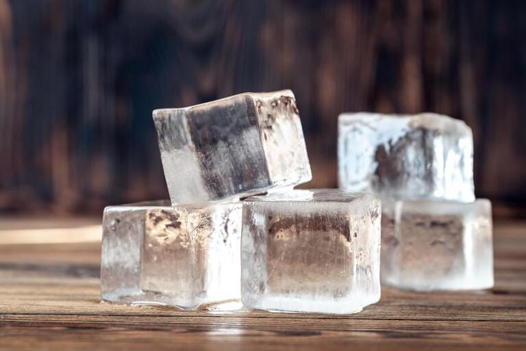 Crystal clear ice cubes on wooden background Crystal clear ice cubes on wooden background