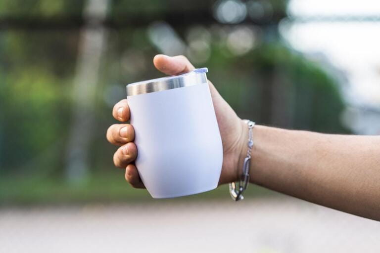 wine tumbler is delicately held by a hand, creating a refined and sophisticated aesthetic atmosphere, white blank tumbler mockup image wine tumbler is delicately held by a hand, creating a refined and sophisticated aesthetic atmosphere, white blank tumbler mockup image