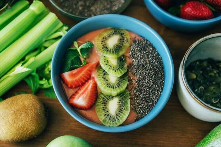Top view of a bowl with smoothies and fruits and chia seeds.