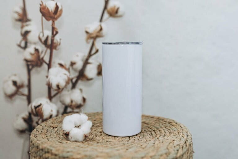 Blank white steel tumbler with floral background. White steel tumbler mockup. Blank white steel tumbler with floral background. White steel tumbler mockup.